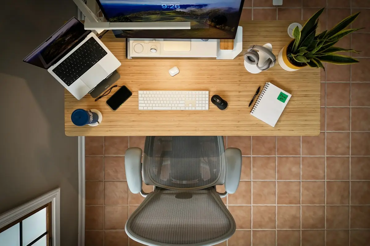 Vista de cima de mesa com notebook, teclado e mouse
